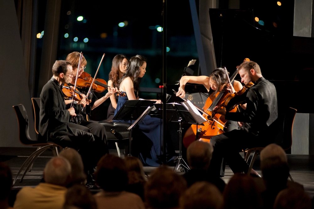 A string quartet and pianist perform by night at the Hunter Museum